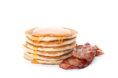 Delicious pancakes with maple syrup and fried bacon on white background