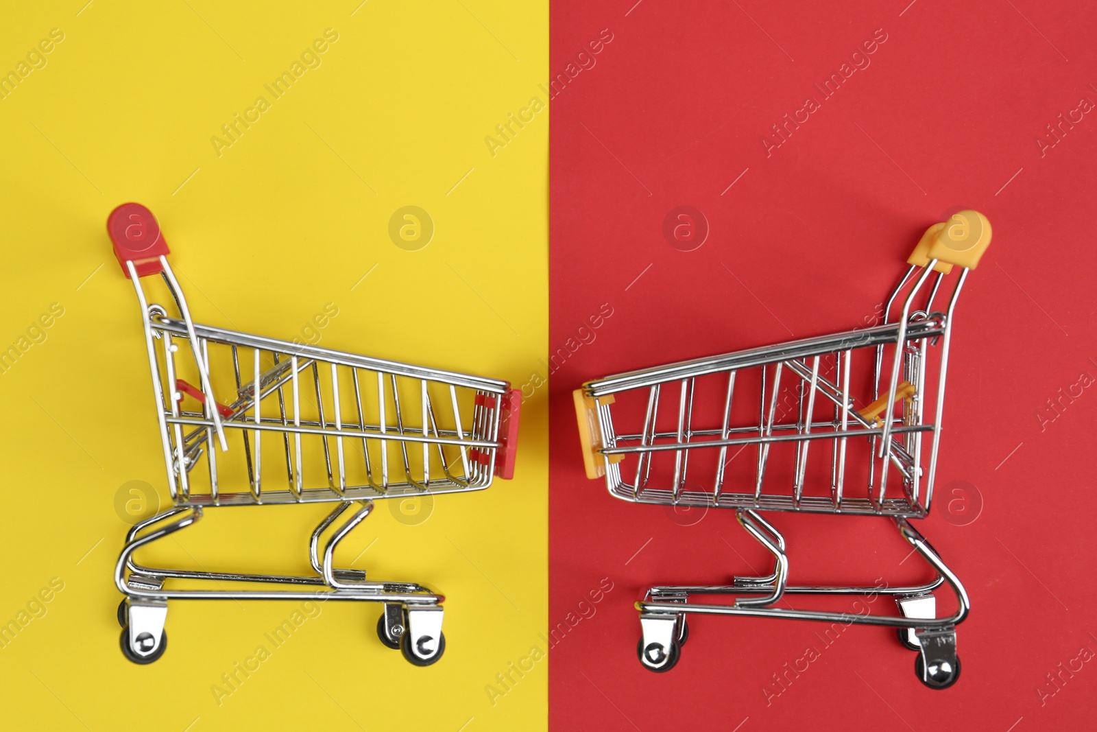 Photo of Flat lay composition with empty shopping trolleys on color background