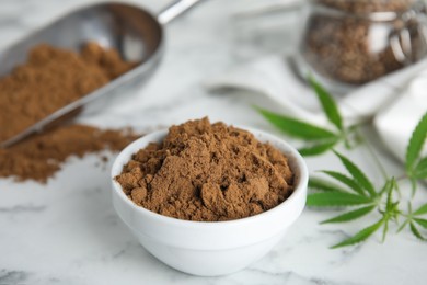 Photo of Hemp protein powder and fresh leaves on white marble table, closeup