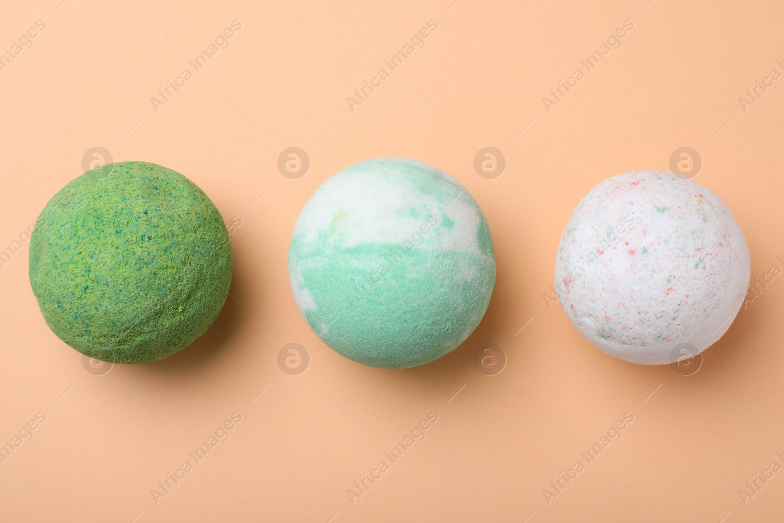 Photo of Colorful bath bombs on beige background, flat lay