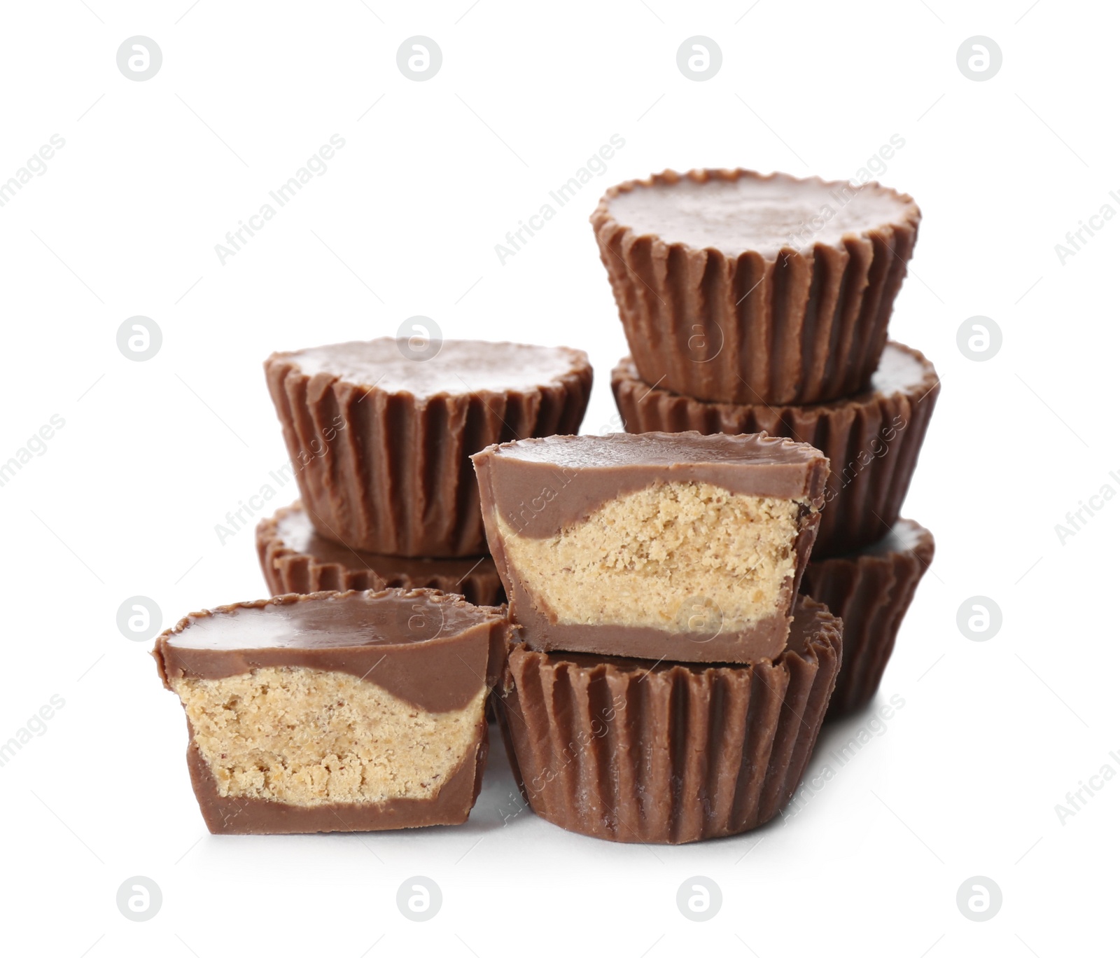 Photo of Cut and whole delicious peanut butter cups on white background