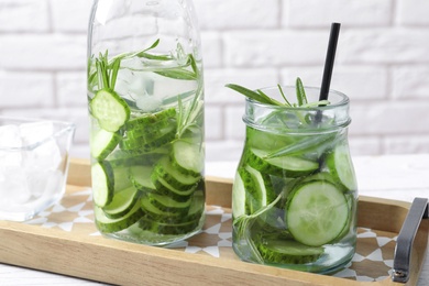 Natural lemonade with cucumber and rosemary in glassware on table