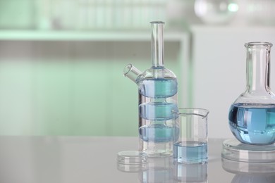 Laboratory analysis. Different glassware with liquid on white table indoors. Space for text