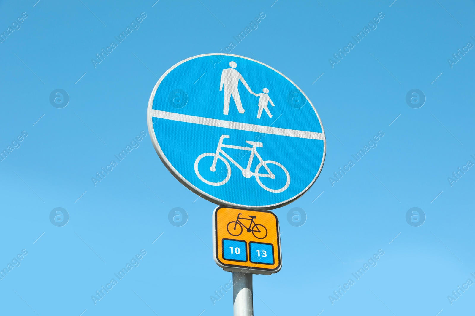 Photo of Different traffic signs against blue sky, low angle view