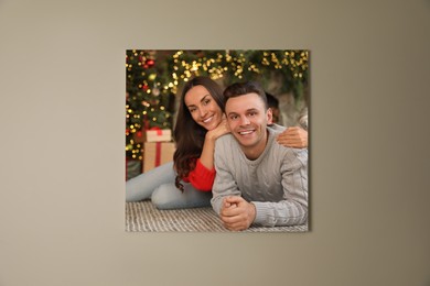 Image of Canvas with printed photo of happy couple in room decorated for Christmas on beige wall