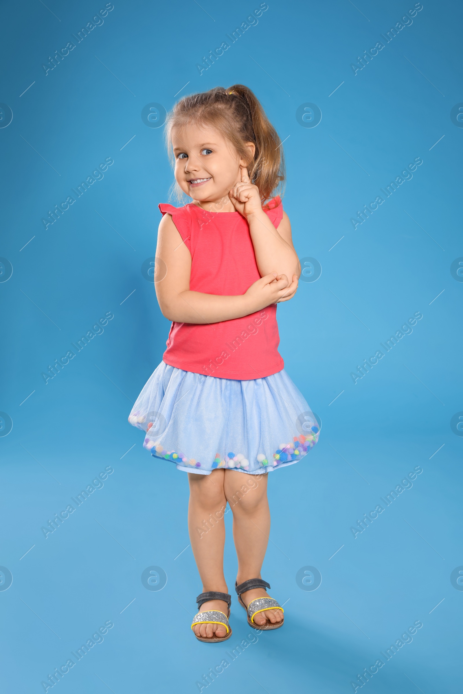 Photo of Full length portrait of cute little girl against color background