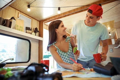 Young travelers with world map planning trip in motorhome