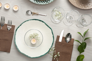 Photo of Elegant table setting with green plants on white wooden background, flat lay