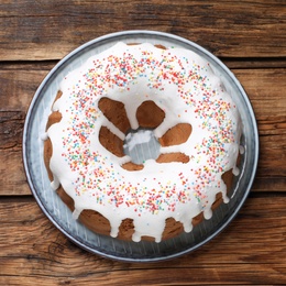 Glazed Easter cake with sprinkles on wooden table, top view