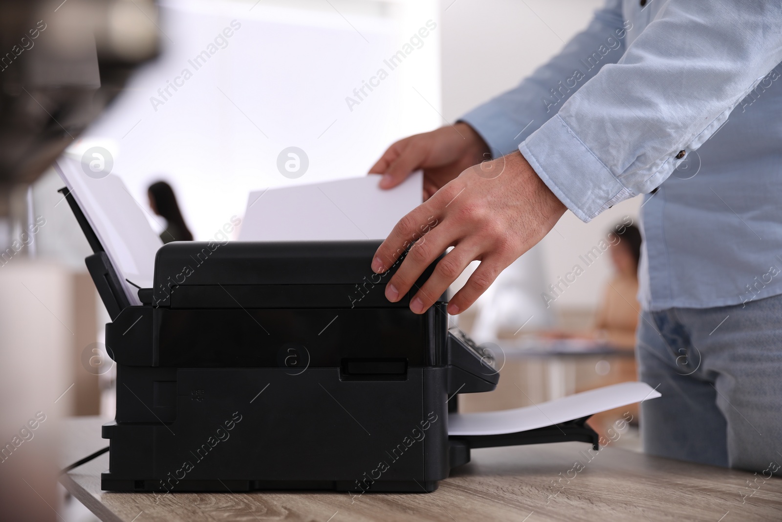 Photo of Employee using modern printer in office, closeup