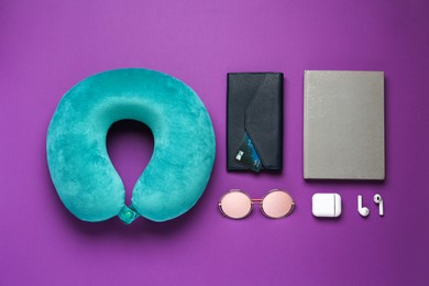 Photo of Flat lay composition with turquoise travel pillow on purple background