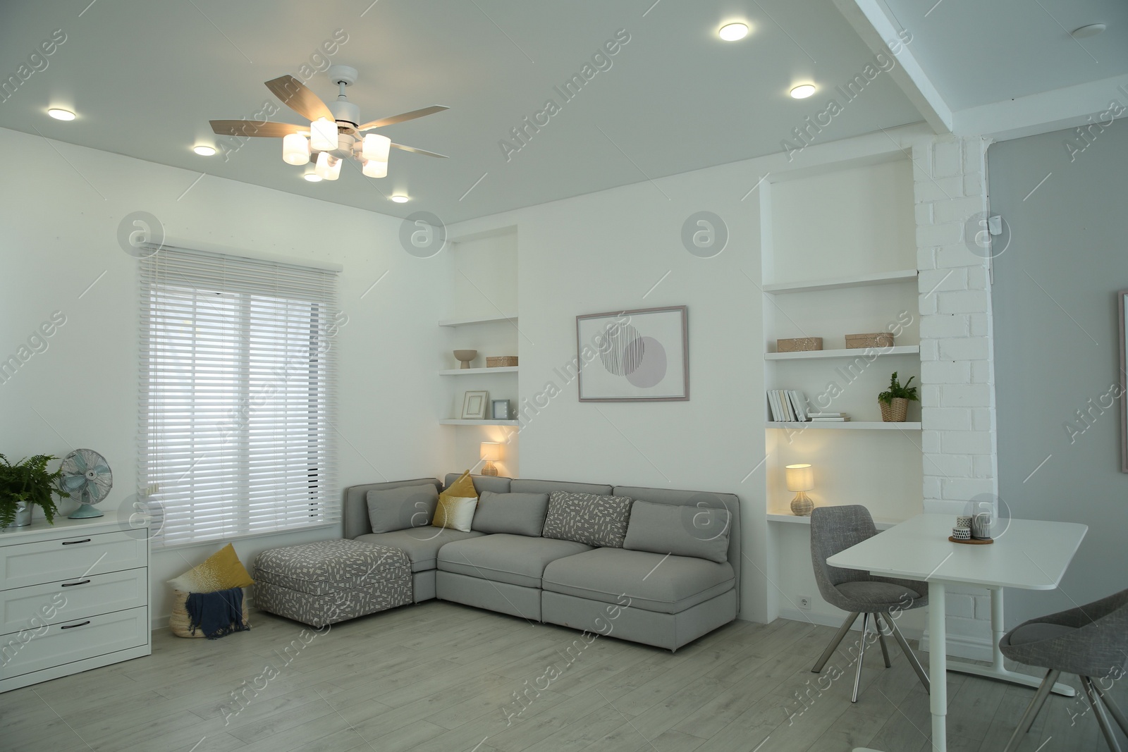 Photo of Comfortable furniture, ceiling fan and accessories in stylish living room