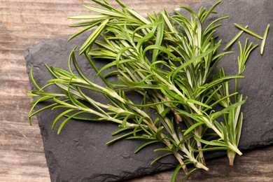 Photo of Fresh green rosemary on wooden table, above view