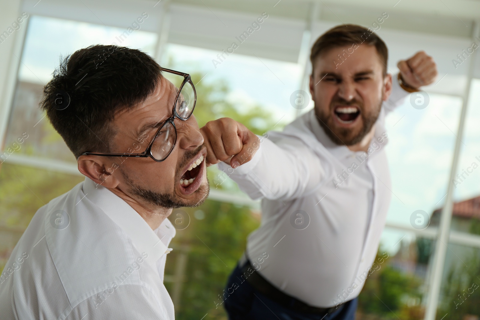 Photo of Emotional colleagues fighting in office. Workplace conflict