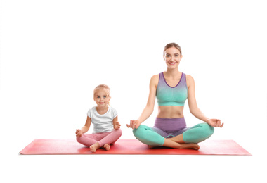 Photo of Young woman and her daughter doing exercise isolated on white. Home fitness