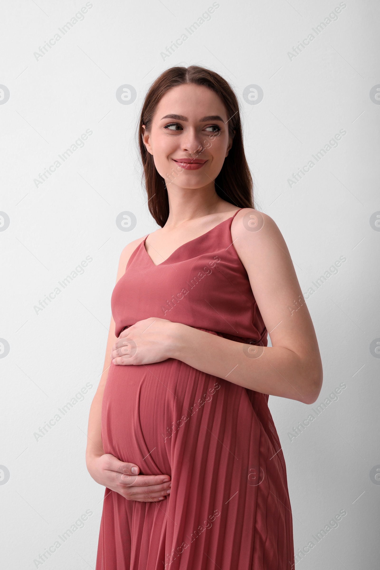 Photo of Beautiful young pregnant woman on light background