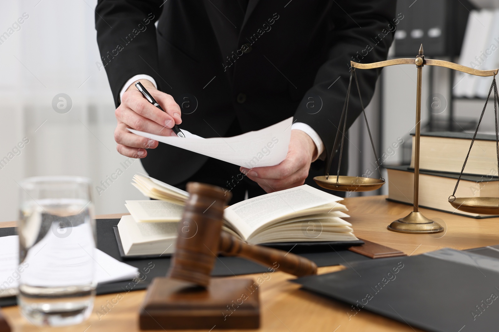 Photo of Lawyer working with document at wooden table, closeup