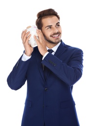 Young businessman with piggy bank on white background