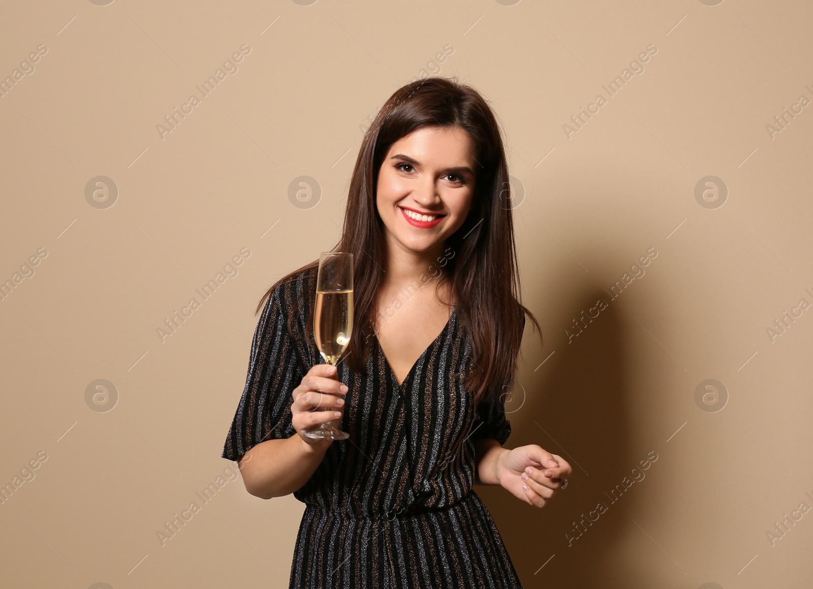 Photo of Portrait of happy woman with champagne in glass on color background