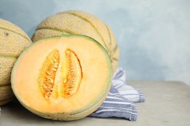 Photo of Tasty fresh melons on light grey table, closeup
