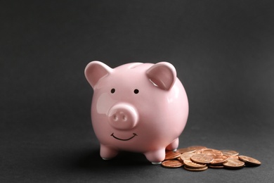 Photo of Piggy bank and coins on black background