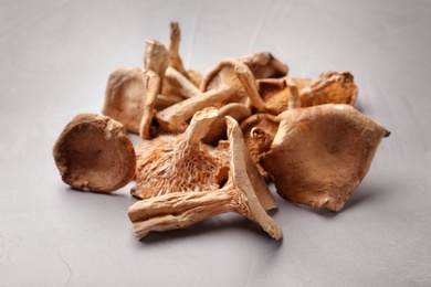 Photo of Heap of dried mushrooms on color background, closeup