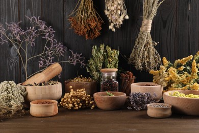 Photo of Many different dry herbs and flowers on wooden table