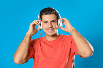 Photo of Man listening to audiobook on light blue background