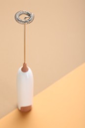 Photo of White milk frother wand on color background, closeup. Space for text