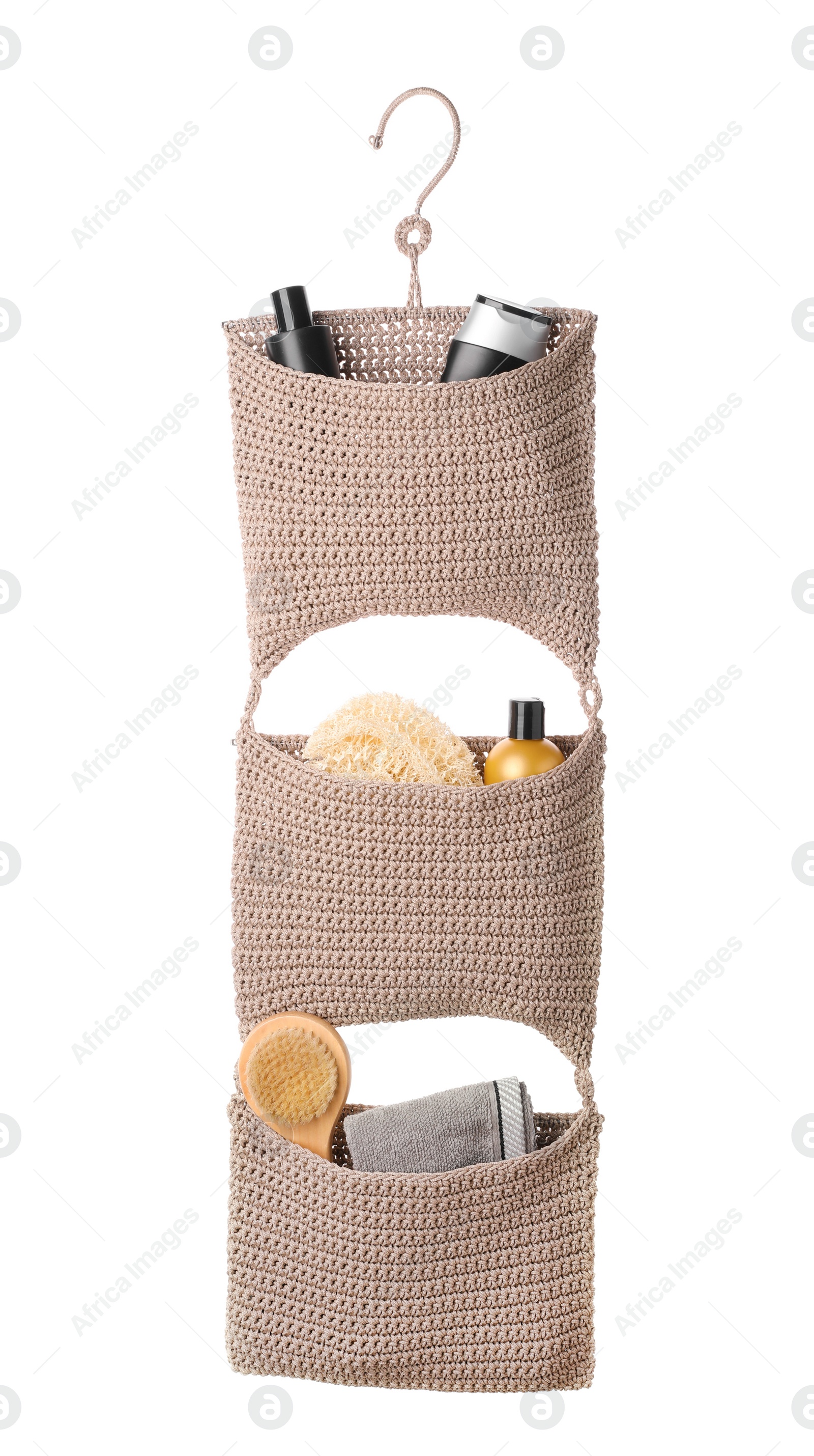 Photo of Stylish knitted organizer with toiletries and brush on white background. Bath accessory