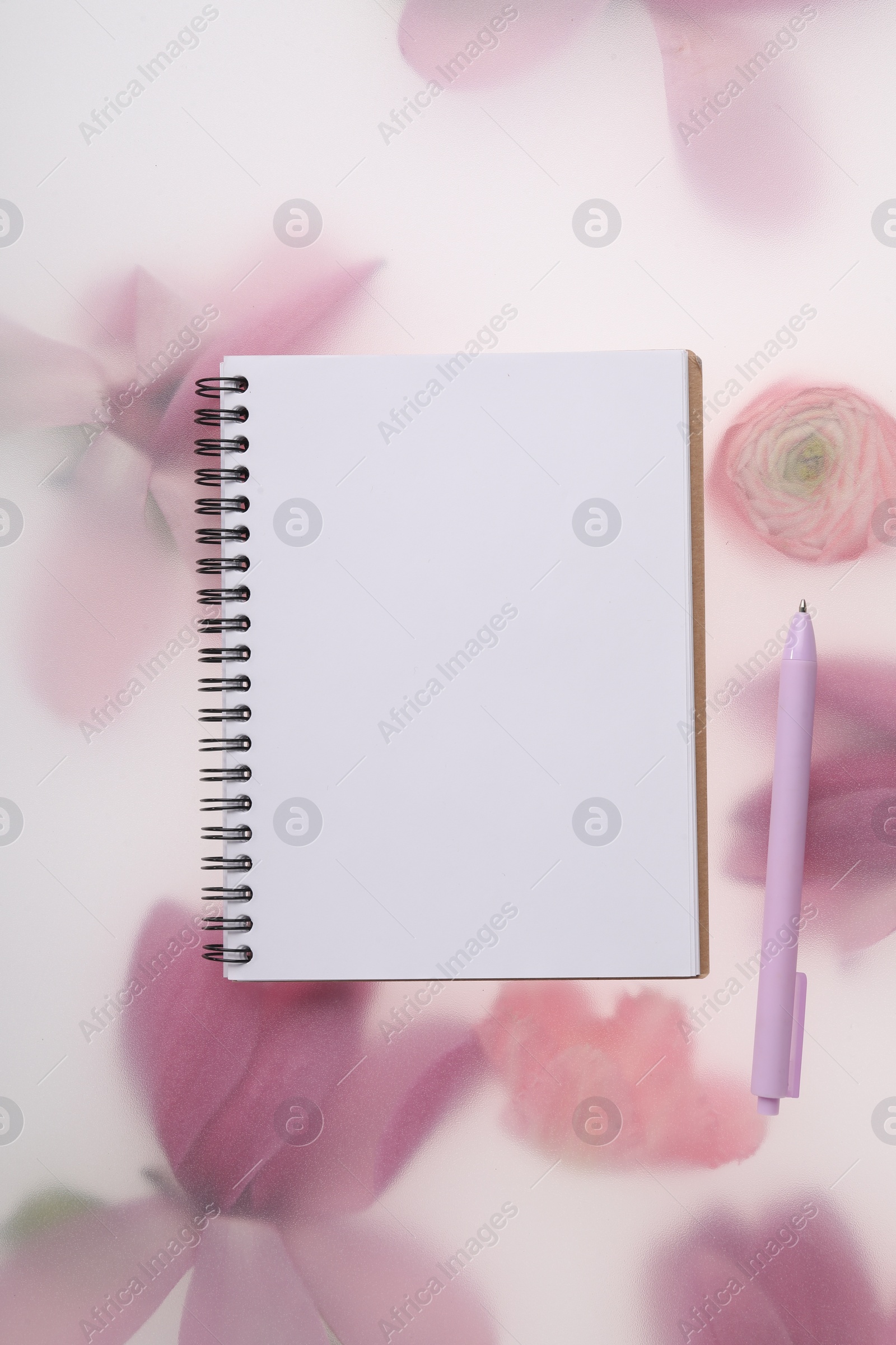 Photo of Guest list. Notebook and pen on spring floral background, flat lay