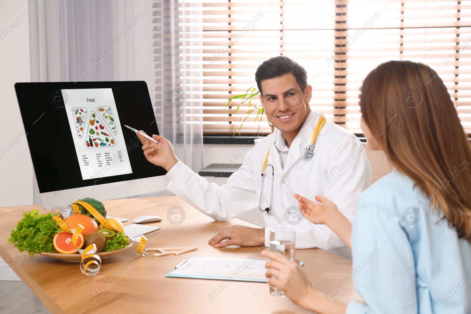 Photo of Nutritionist consulting patient at table in clinic