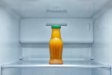 Bottle of juice on shelf in refrigerator