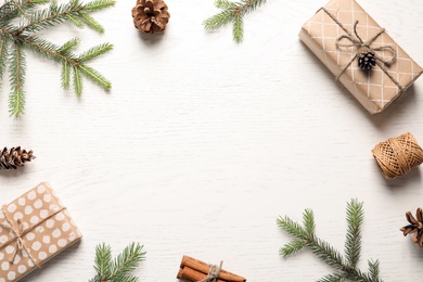 Photo of Flat lay composition with Christmas gifts and fir branches on light background