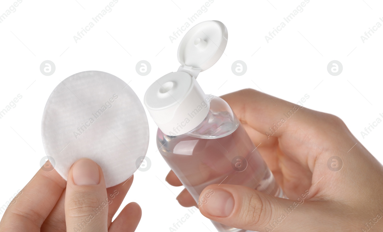 Photo of Woman holding bottle with micellar water and cotton pad against white background, closeup