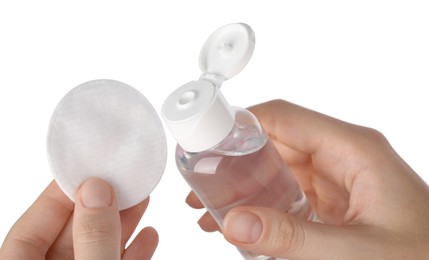 Photo of Woman holding bottle with micellar water and cotton pad against white background, closeup
