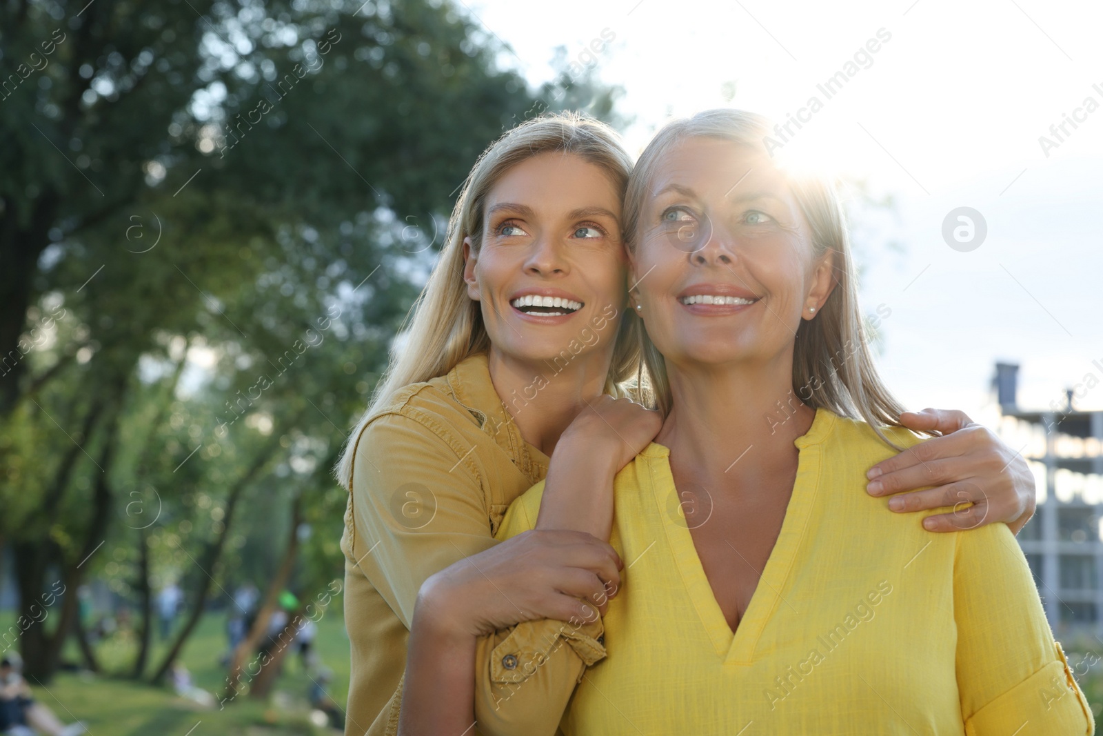 Photo of Family portrait of happy mother and daughter spending time together outdoors on sunny day