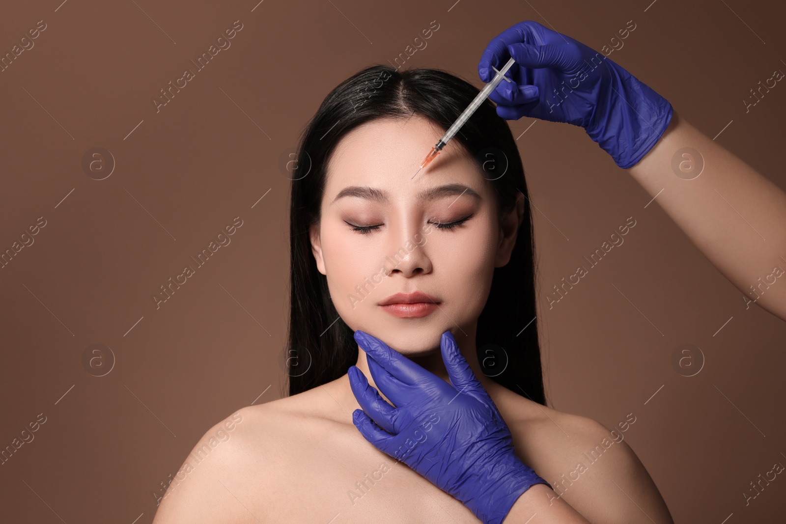 Photo of Woman getting facial injection on brown background