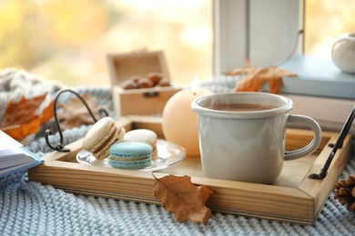 Photo of Tray with breakfast near stack of books on windowsill