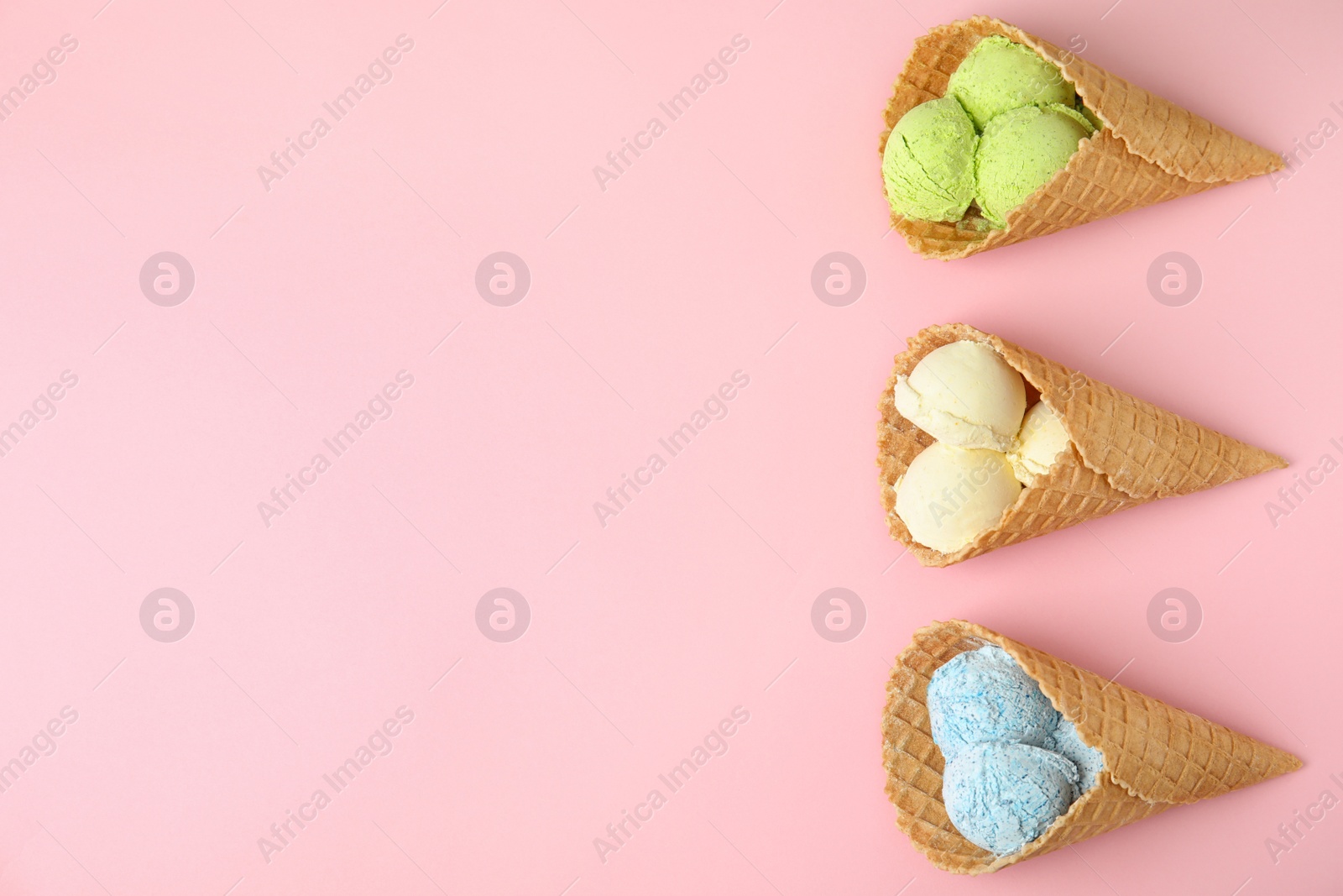 Photo of Flat lay composition with delicious ice creams in waffle cones on color background, space for text