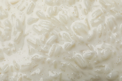 Photo of Delicious rice pudding as background, closeup view