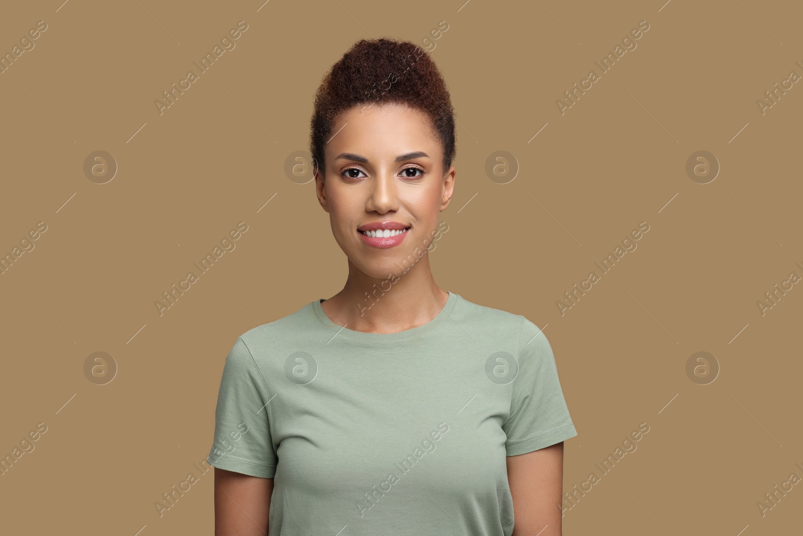 Photo of Portrait of beautiful young woman on light brown background