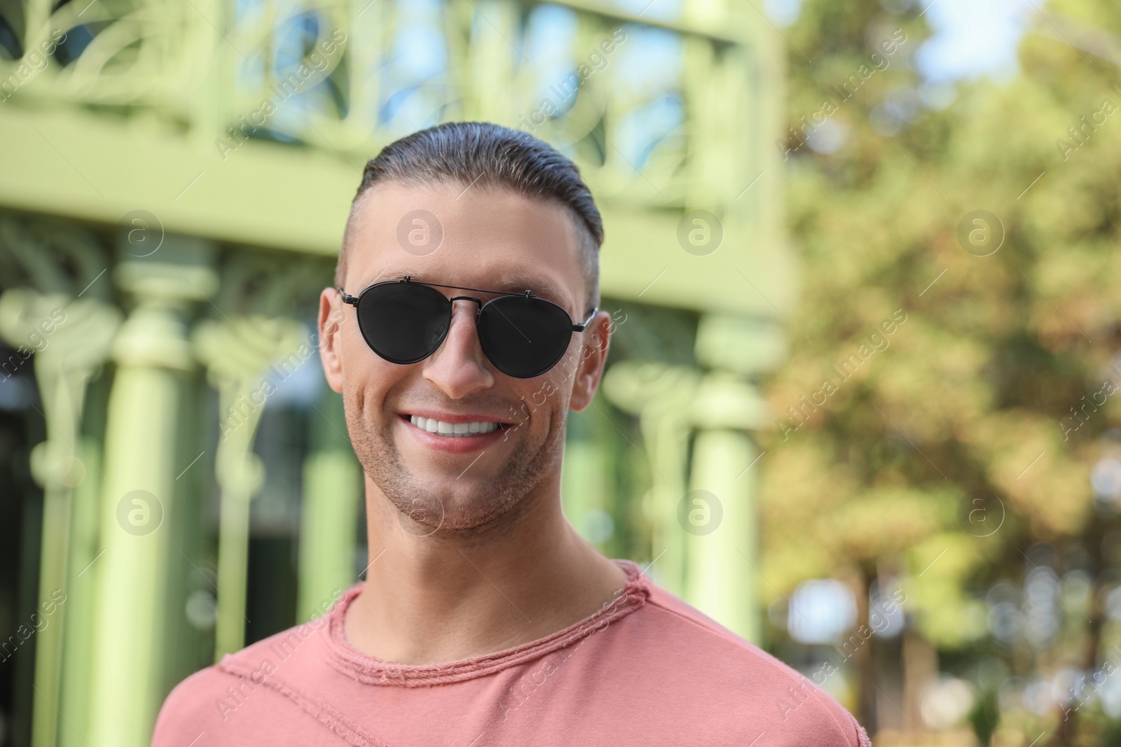 Photo of Portrait of handsome man in sunglasses outdoors, space for text