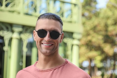 Photo of Portrait of handsome man in sunglasses outdoors, space for text
