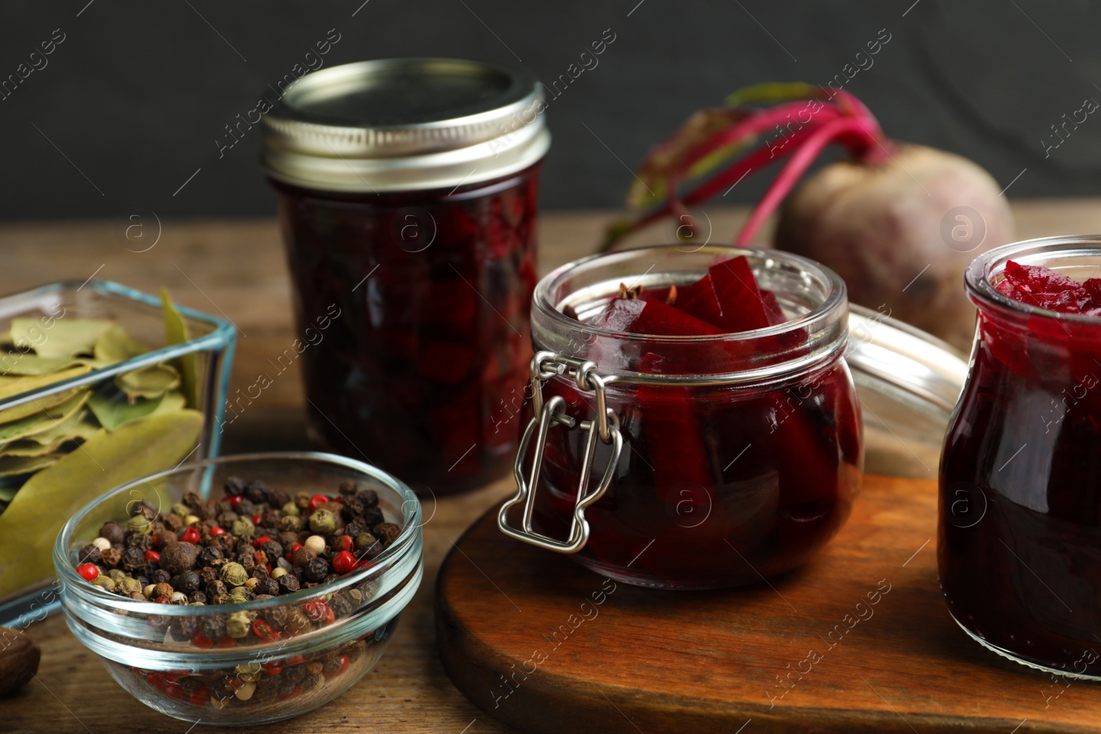 Photo of Delicious pickled beets and spices on wooden table