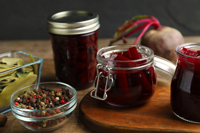 Photo of Delicious pickled beets and spices on wooden table