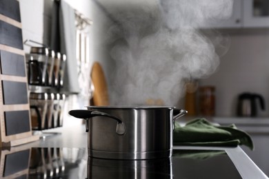 Photo of Steaming pot on electric stove in kitchen