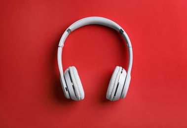 Photo of Wireless headphones on color background, top view