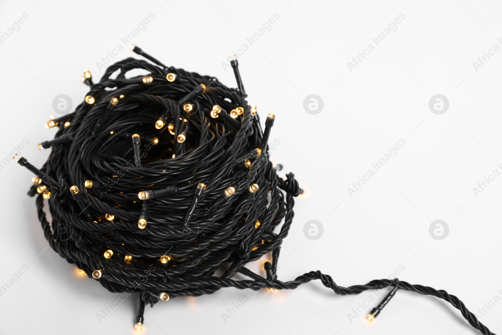 Photo of Beautiful Christmas lights on white background, closeup