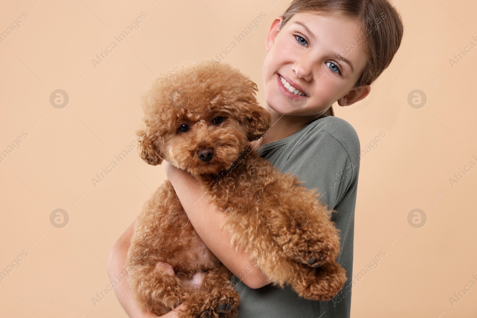 Photo of Little child with cute puppy on beige background. Lovely pet